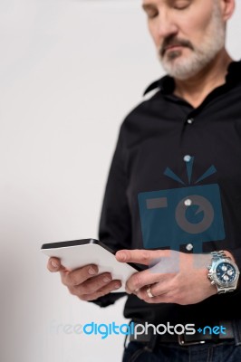 Mature Man Looking At His Digital Tablet Stock Photo