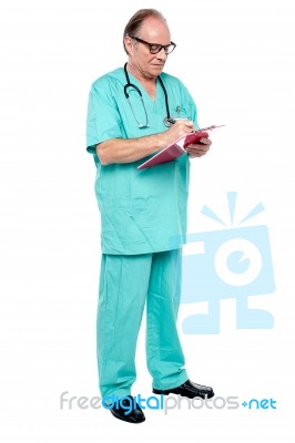 Mature Medical Practitioner Writing Case History Of A Patient Stock Photo