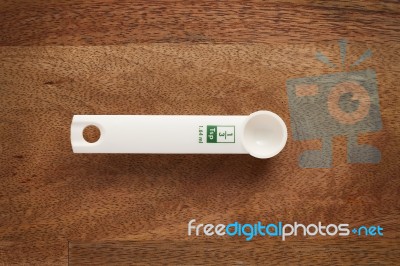 Measuring Spoon On Wooden Background Stock Photo