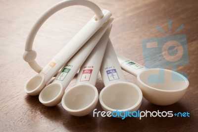 Measuring Spoons In Varying Sizes On Wooden Background Stock Photo