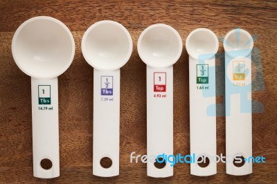 Measuring Spoons In Varying Sizes On Wooden Background Stock Photo