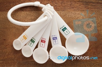 Measuring Spoons In Varying Sizes On Wooden Background Stock Photo