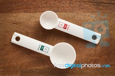 Measuring Spoons In Varying Sizes On Wooden Background Stock Photo