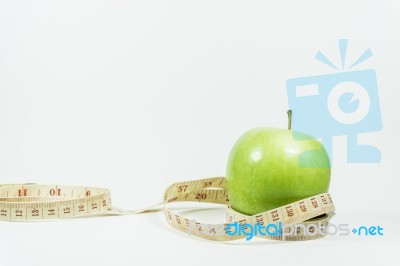 Measuring Tape Wrapped Around A Green Apple. Concept Of Diet Stock Photo