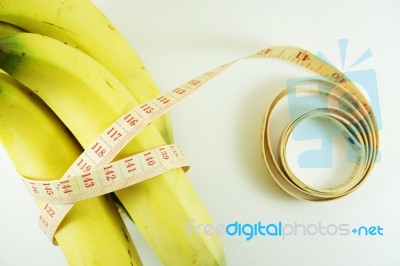 Measuring Tape Wrapped Around Bananas. Concept Of Diet Stock Photo