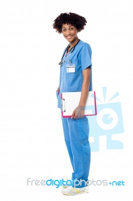 Medical Expert Posing Sideways, Holding Clipboard Stock Photo