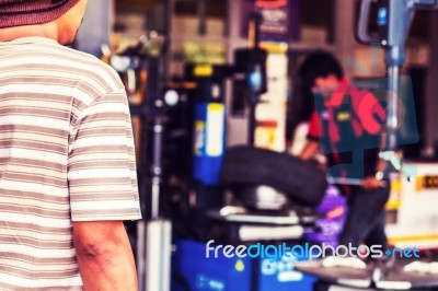 Men Waiting For A Change Of Tires Stock Photo