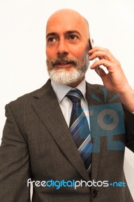 Middle-aged Businessman Listening On Smartphone At Home Stock Photo