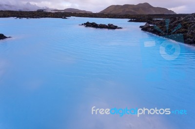 Milky White And Blue Water Between The Lava Stones Covered With Moss Stock Photo