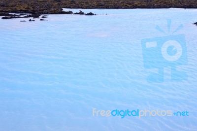 Milky White And Blue Water Between The Lava Stones Covered With Moss Stock Photo