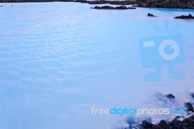 Milky White And Blue Water Between The Lava Stones Covered With Moss Stock Photo