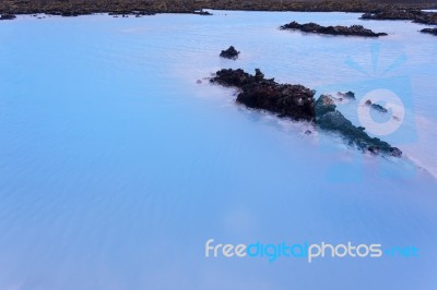 Milky White And Blue Water Between The Lava Stones Covered With Moss Stock Photo