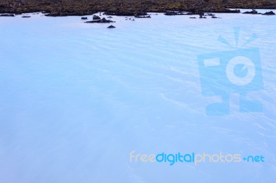 Milky White And Blue Water Between The Lava Stones Covered With Moss Stock Photo