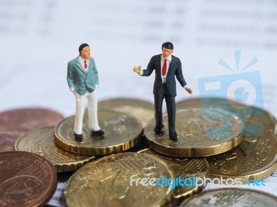 Miniature Businessman Stand On Euro Coins And Book Bank. Busines… Stock Photo