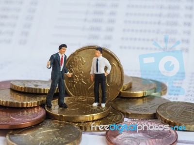 Miniature Businessman Stand On Euro Coins And Book Bank. Busines… Stock Photo