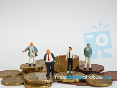 Miniature Businessman Stand On Euro Coins And Book Bank. Busines… Stock Photo