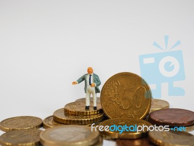 Miniature Businessman Stand On Euro Coins And Book Bank. Busines… Stock Photo