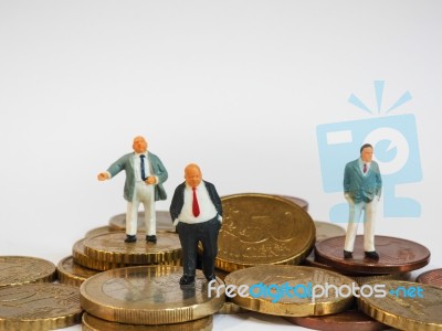 Miniature Businessman Stand On Euro Coins And Book Bank. Busines… Stock Photo