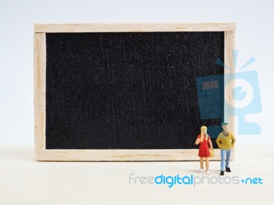 Miniature Children Standing In Front Of A Blackboard On Wooden B… Stock Photo