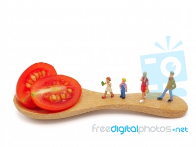 Miniature Children Standing On Fresh Grape Or Cherry Tomato With… Stock Photo