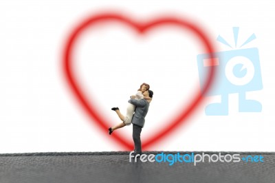 Miniature Couple Hugging On White Background Stock Photo