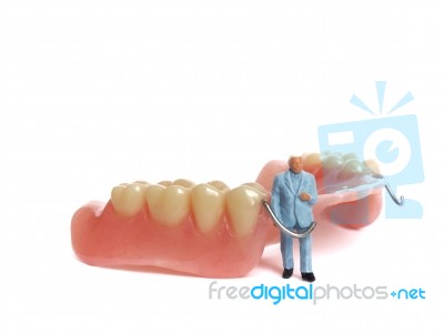 Miniature Elderly Standing On Removable Denture, On White Background. Dental Health Concept Stock Photo