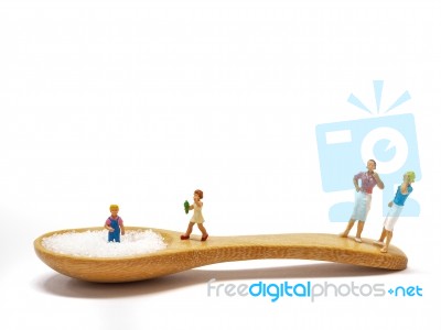 Miniature Little Children Standing On A Wooden Spoon And Thinking Of Sugar, Diet, Fat And Diabetes. Health Care Concept Stock Photo