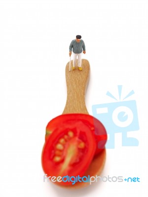 Miniature Ole Man Standing On Fresh Grape Or Cherry Tomato With Stock Photo