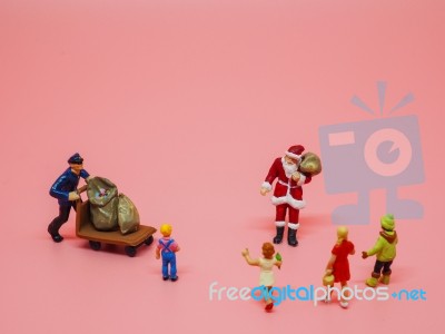 Miniature Santa Claus, A Man With Trolly And Children On Pink Ba… Stock Photo