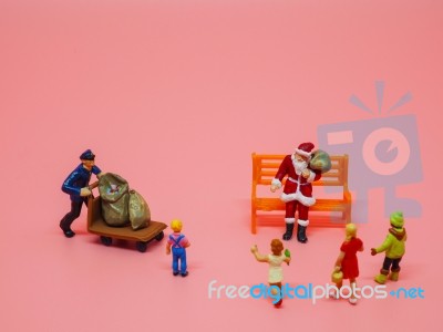 Miniature Santa Claus, A Man With Trolly And Children On Pink Ba… Stock Photo