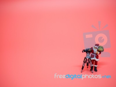 Miniature Santa Claus With Vdo Camera On Pink Background. Christ… Stock Photo