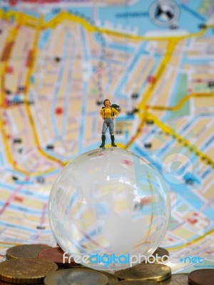 Miniature Traveller Or Backpacker Stand On Globe Of Glass, Euro Stock Photo