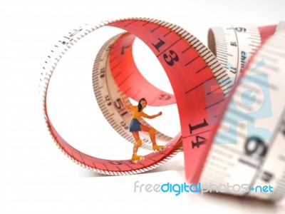 Miniature Woman Skating On Measuring Tape, Thinking Of Weight Lo… Stock Photo