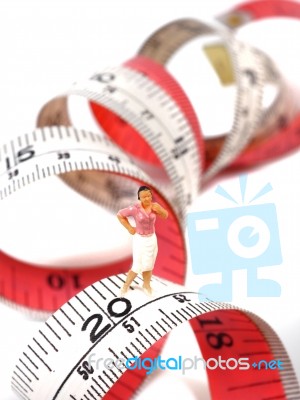 Miniature Woman Standing Near Measuring Tape, Thinking Of Weight… Stock Photo