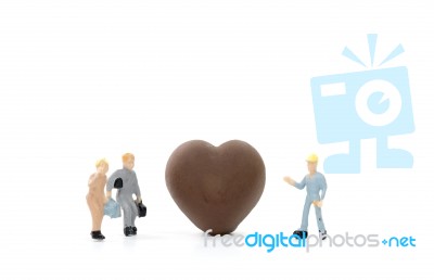 Miniature Worker Making Heart Shaped Chocolate On White Background Stock Photo