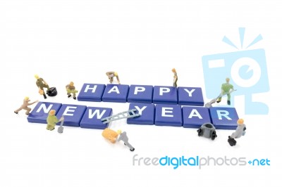 Miniature Worker Team Building Word Happy New Year On White Background Stock Photo