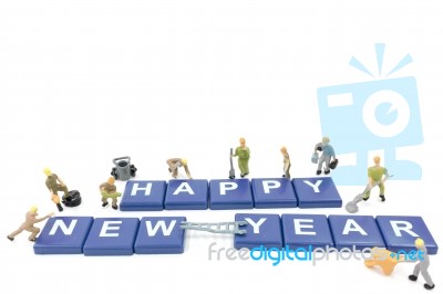 Miniature Worker Team Building Word Happy New Year On White Background Stock Photo