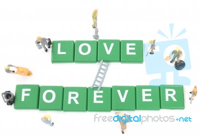 Miniature Worker Team Building Word Love Forever On White Background Stock Photo