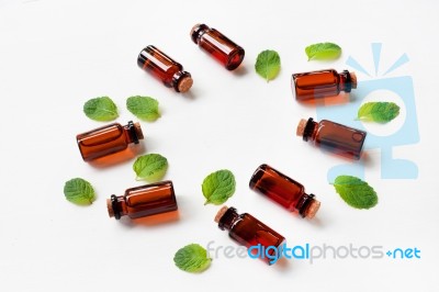 Mint Essential Oil In A Glass Bottle With Leaves On White Backgr… Stock Photo