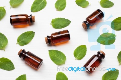 Mint Essential Oil In A Glass Bottle With Leaves On White Backgr… Stock Photo