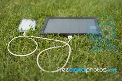 Mobile Phone Charging With Solar Energy - Charger Stock Photo