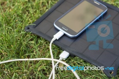 Mobile Phone Charging With Solar Energy - Charger Stock Photo