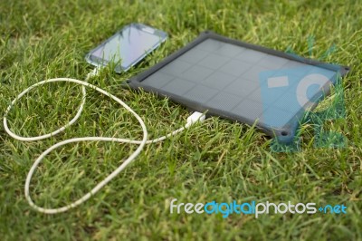 Mobile Phone Charging With Solar Energy - Charger Stock Photo