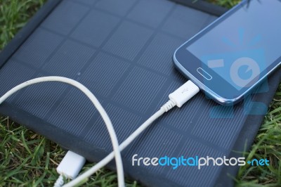 Mobile Phone Charging With Solar Energy - Charger Stock Photo