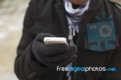 Mobile Phone In Hands With Glowes, Cold Weather Stock Photo