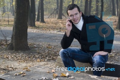 Mobile Phone In The Park And Man With Smile Stock Photo