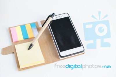 Mobile Phone Notebook And Pen On White Background Stock Photo