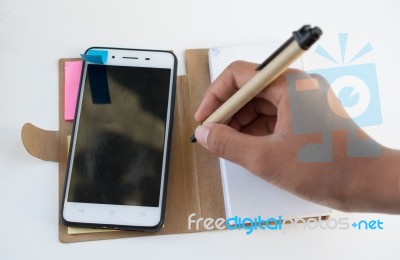 Mobile Phone Notebook And Pen On White Background Stock Photo