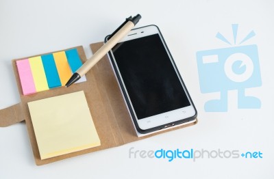 Mobile Phone Notebook And Pen On White Background Stock Photo