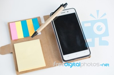 Mobile Phone Notebook And Pen On White Background Stock Photo